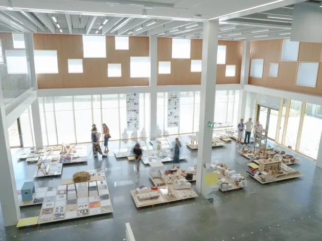 Big open space with windows and exhibited material seen from a distance