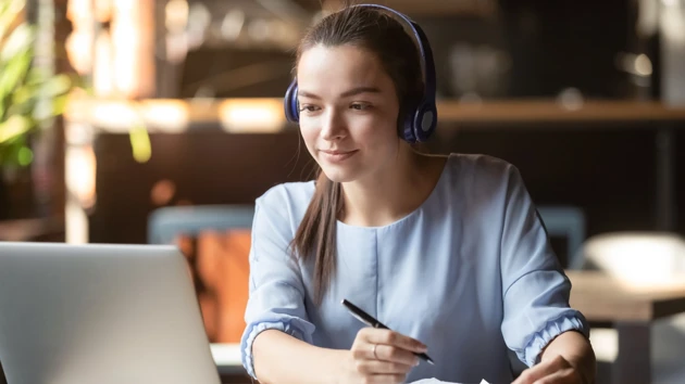 Kvinna som sitter i framför datorn i ett digitalt möte.
