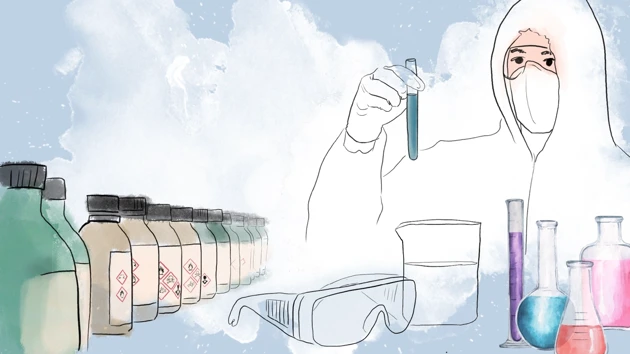 Person with protective lab clothing holding a test tube with bottles in the foreground.