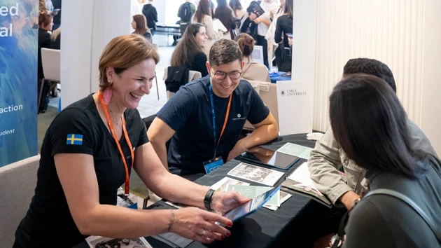 University staff meet prospective students at a fair.