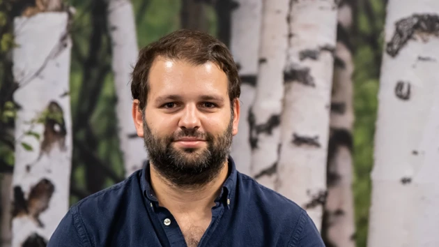 En man som står framför en målning av träd