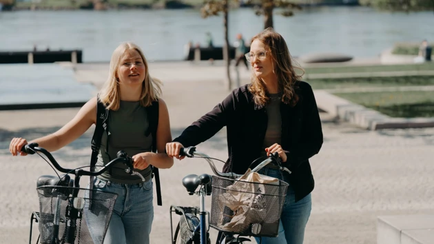 Studenter som njuter av höstsolen utanför Lindellhallen på Campus Umeå.